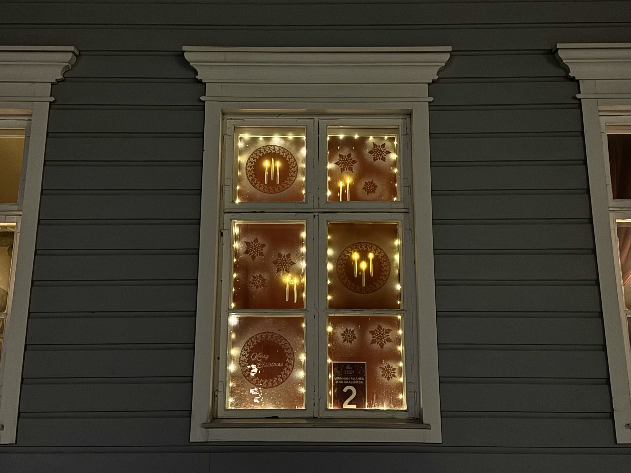 Old Town Raahe Advent Calendar window presenting snowflakes and candles.