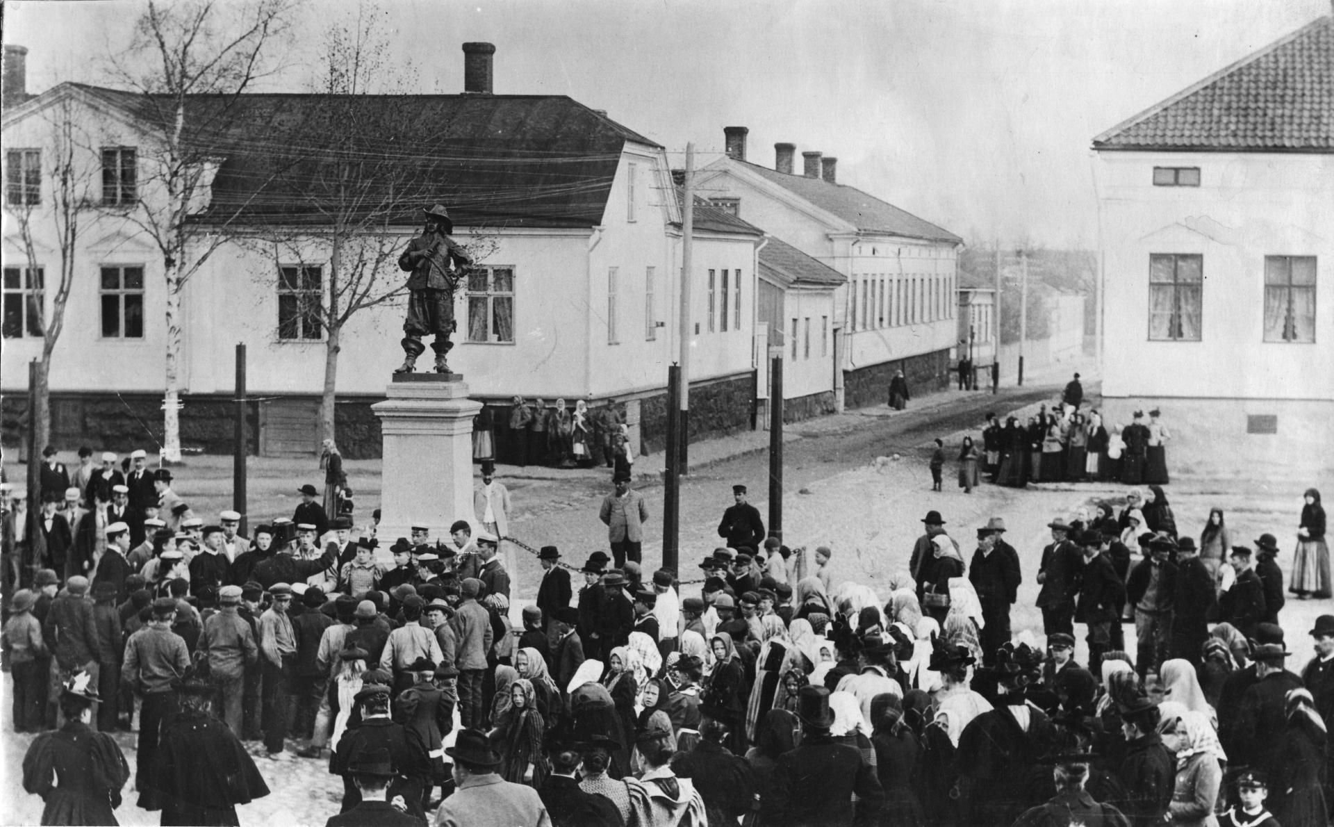 A black-and-white vintage photograph showing people at the May Day market at Pekkatori in the early 1900s.