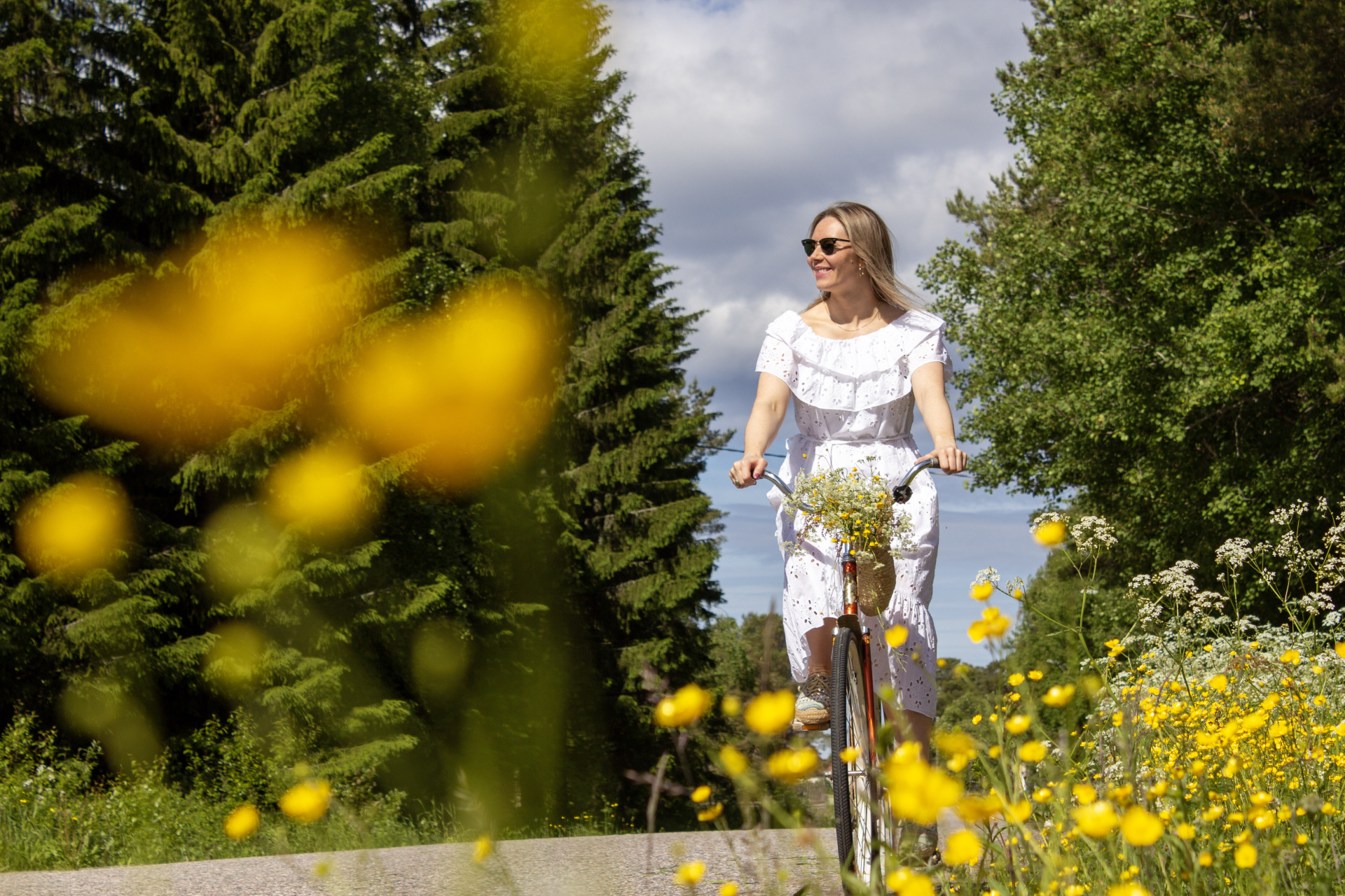 Nainen pyöräilee kesäisessä Karinkannassa Siikajoella.