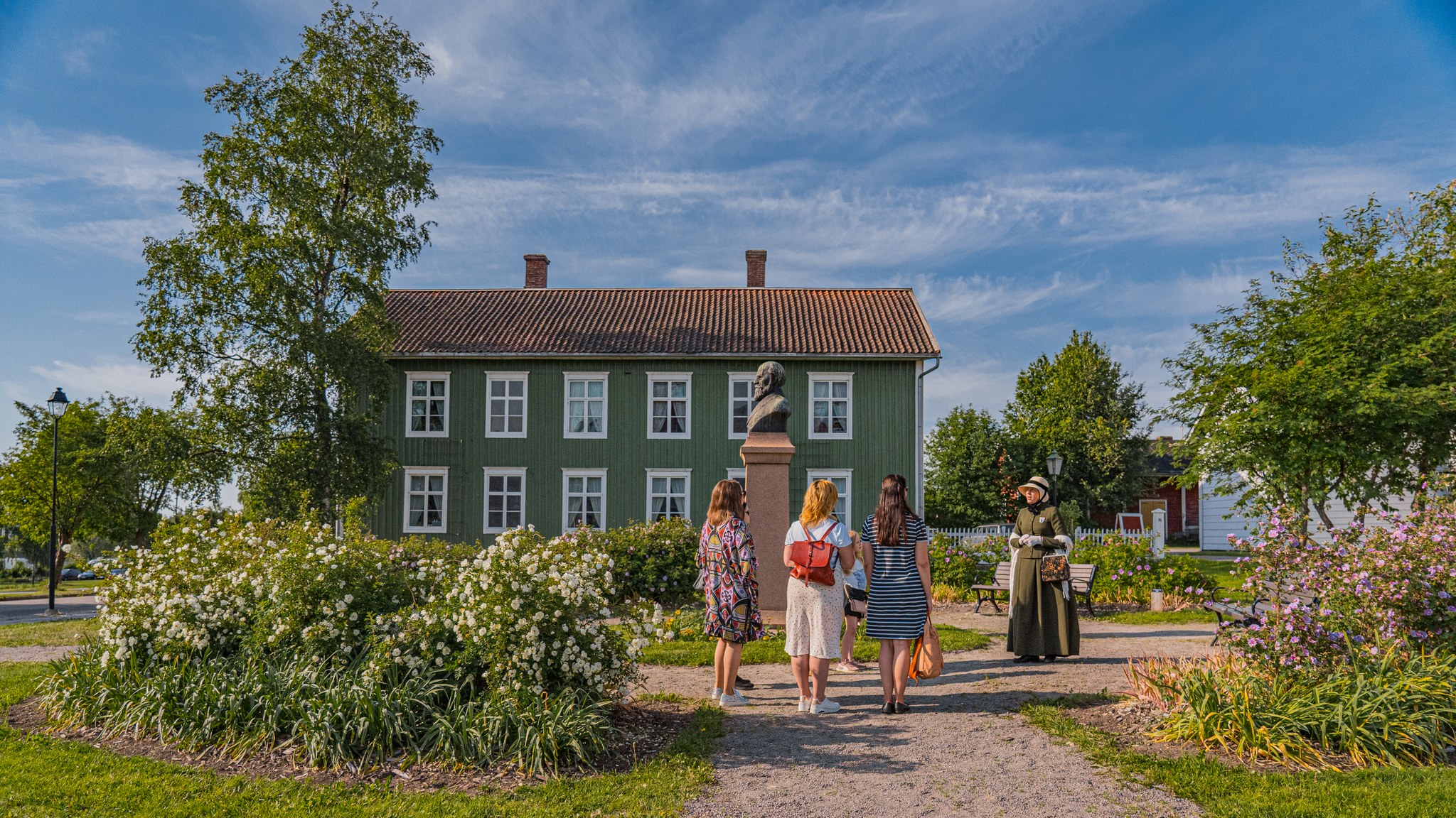 Matkailuopas ja turisteja Soveliuksen talon edessä Wanhassa Raahessa.
