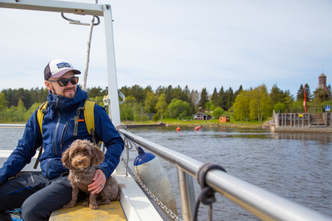 Ihminen veneilee koiran kanssa
