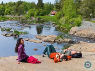 Cyclists lounging on the rocks of Hourunkoski Rapids in Pyhäjoki.