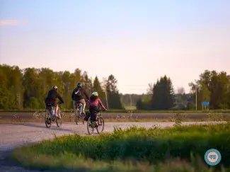 Cyclists sitting at a lean-to in the forest.