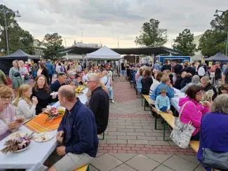 Kesäillan kattaus Raahe ruokailijoita pitkien pöytien äärellä