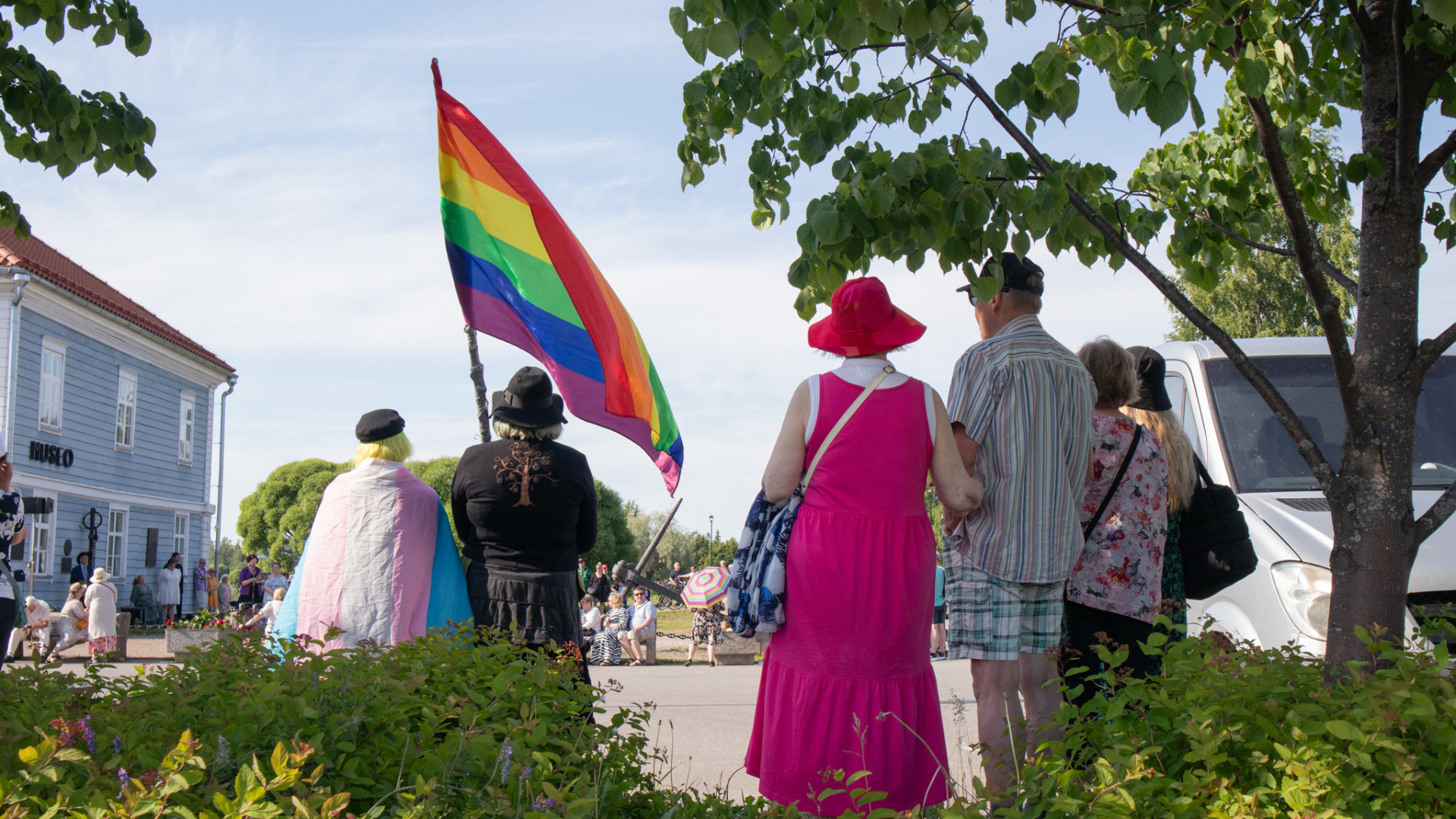 Ihmisiä kantamassa sateenkaarilippua